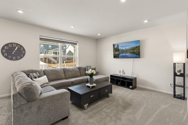 carpeted living area featuring recessed lighting, a textured ceiling, and baseboards