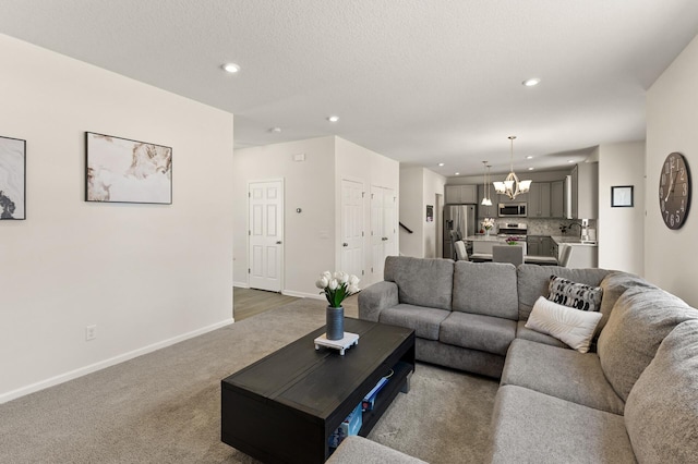 carpeted living area featuring a textured ceiling, recessed lighting, baseboards, and a chandelier