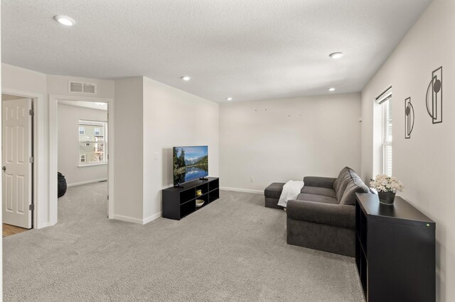 living room with carpet, visible vents, a wealth of natural light, and baseboards