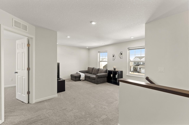 living room with recessed lighting, visible vents, carpet floors, and a textured ceiling