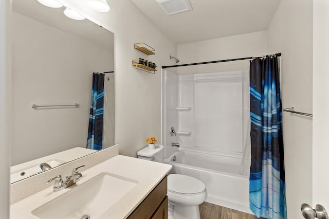 bathroom with visible vents, toilet, wood finished floors, shower / tub combo, and vanity