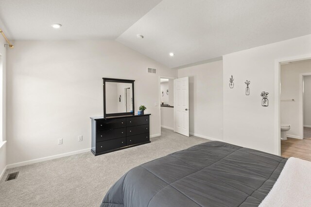 bedroom with visible vents, carpet floors, baseboards, and vaulted ceiling