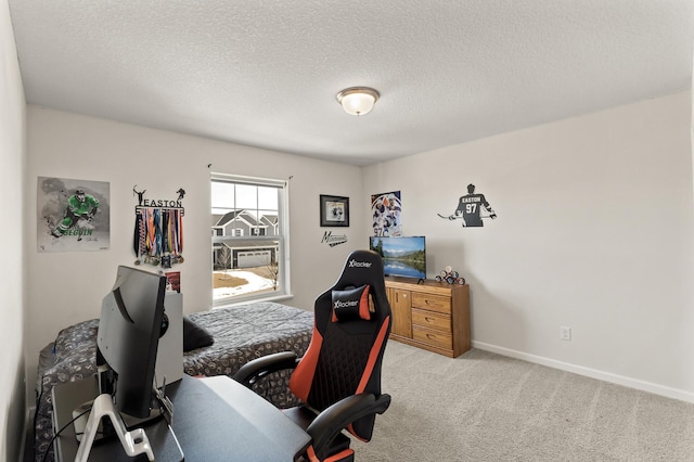 home office featuring light colored carpet, a textured ceiling, and baseboards