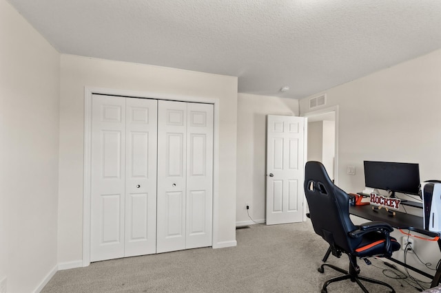 office space with visible vents, baseboards, carpet, and a textured ceiling