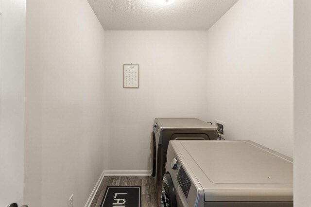 laundry area with independent washer and dryer, a textured ceiling, wood finished floors, baseboards, and laundry area