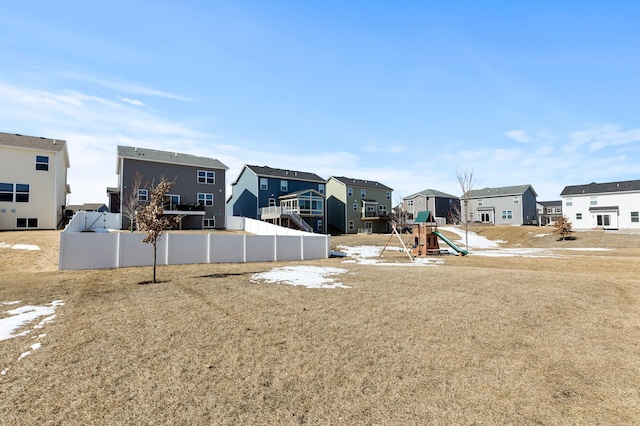 view of yard with playground community, a residential view, and fence