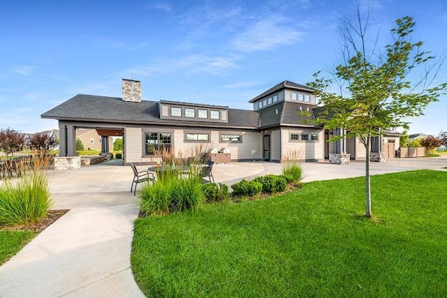 rear view of house with a yard, a patio, and a chimney