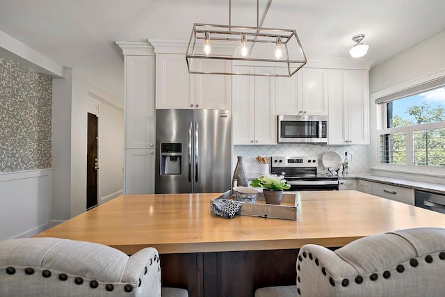 79 Western Ave N Unit 308, Saint Paul, MN 55102 - kitchen with stainless steel appliances, tasteful backsplash, white cabinets, and decorative light fixtures
