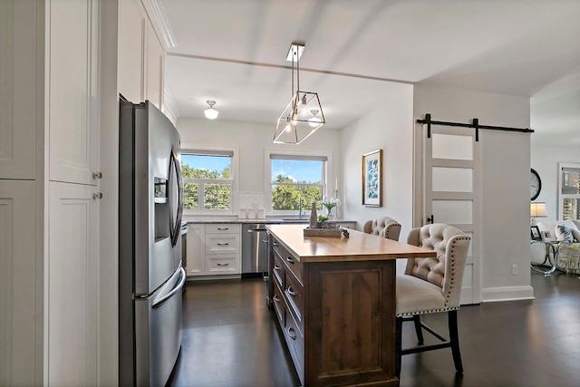 79 Western Ave N Unit 308, Saint Paul, MN 55102 - kitchen with stainless steel appliances, a barn door, a kitchen breakfast bar, white cabinets, and a center island