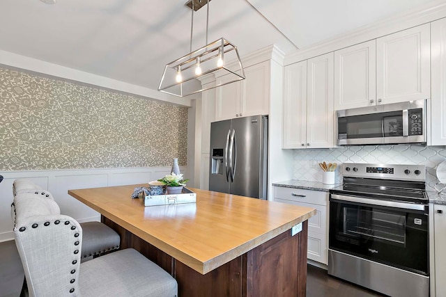 79 Western Ave N Unit 308, Saint Paul, MN 55102 - kitchen with stainless steel appliances, wallpapered walls, white cabinets, a center island, and wainscoting