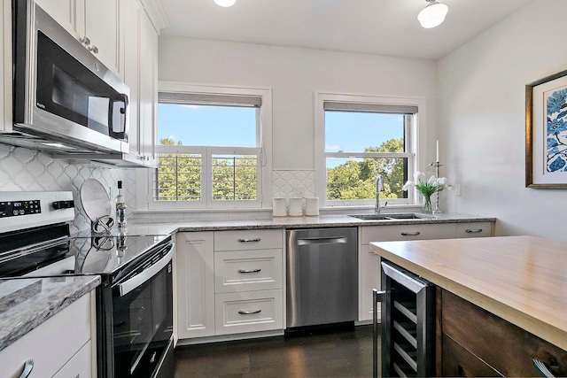 79 Western Ave N Unit 308, Saint Paul, MN 55102 - kitchen with appliances with stainless steel finishes, beverage cooler, plenty of natural light, and backsplash