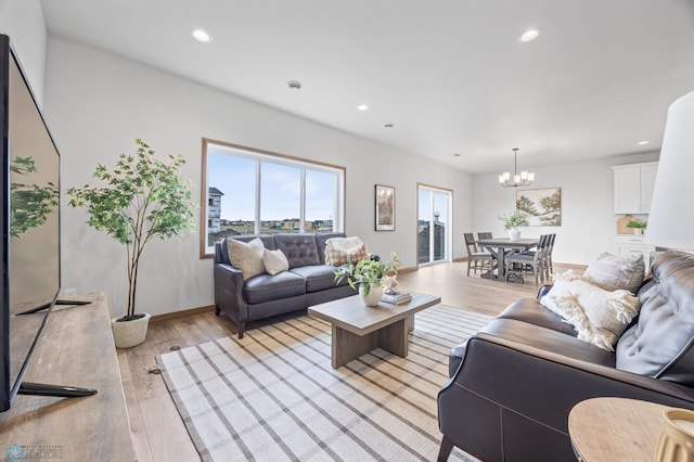 living room featuring recessed lighting, a notable chandelier, and light wood-style floors