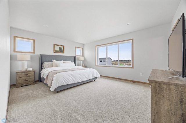 bedroom with baseboards, multiple windows, visible vents, and light colored carpet