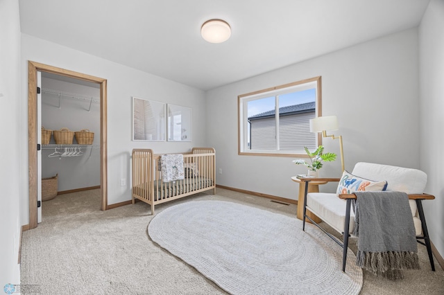 bedroom featuring baseboards, carpet, and a walk in closet