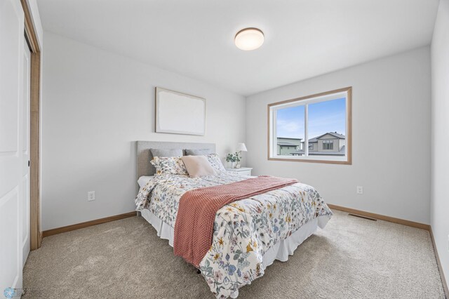 bedroom with baseboards, carpet flooring, and visible vents