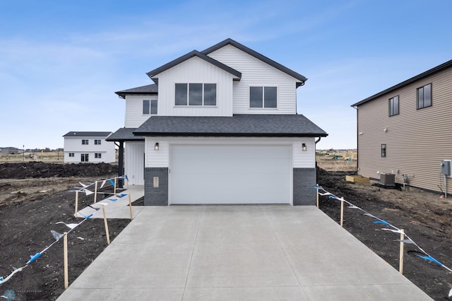 view of front of property featuring brick siding, an attached garage, cooling unit, and driveway