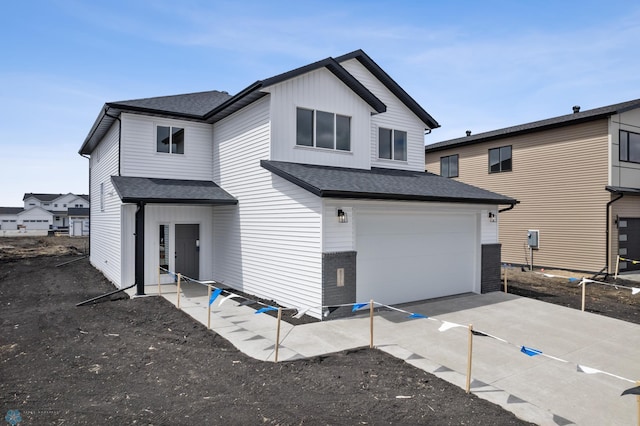 back of house featuring driveway, roof with shingles, and a garage