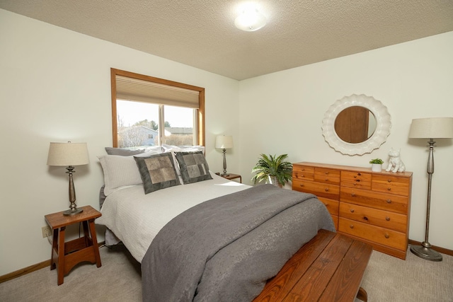 bedroom featuring baseboards, light carpet, and a textured ceiling