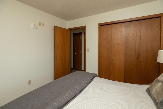 carpeted bedroom with a closet and a textured ceiling