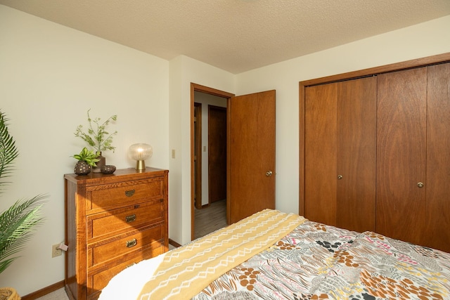 bedroom with baseboards, a closet, and a textured ceiling