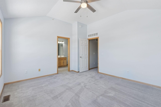 unfurnished bedroom featuring light colored carpet, vaulted ceiling, baseboards, and visible vents