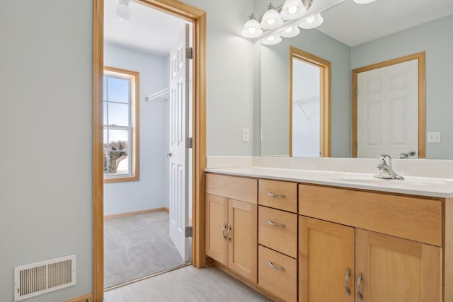 bathroom featuring visible vents, baseboards, and vanity