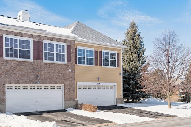 view of side of property with brick siding, an attached garage, and a shingled roof