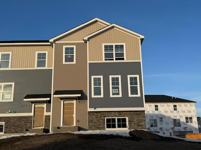 view of front facade with stone siding and board and batten siding