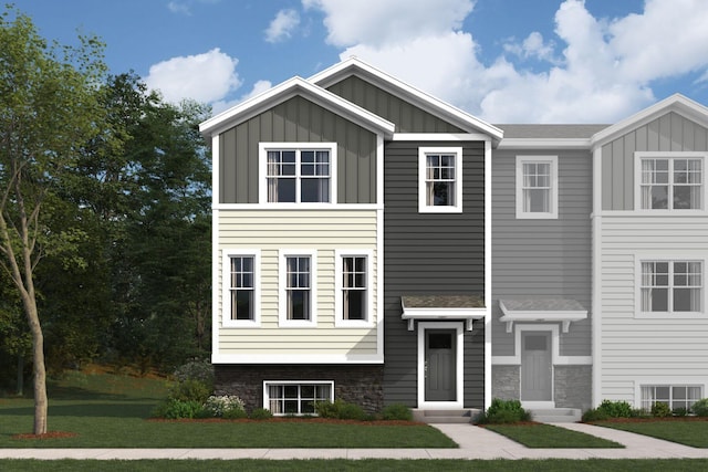 view of front of home with entry steps, stone siding, board and batten siding, and a front lawn