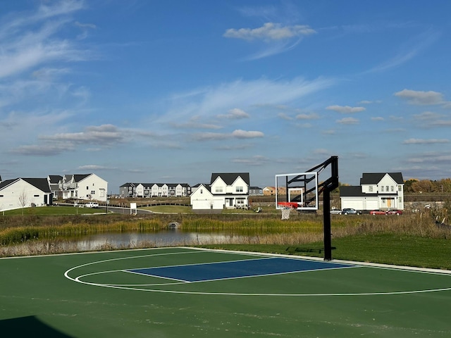 view of basketball court featuring a residential view, community basketball court, and a water view