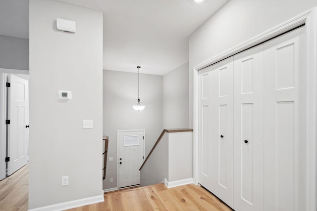 foyer entrance with light wood-type flooring and baseboards