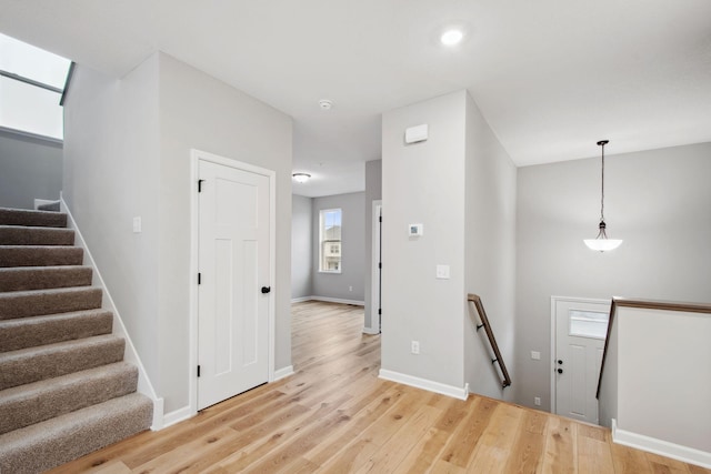 foyer featuring baseboards and light wood finished floors