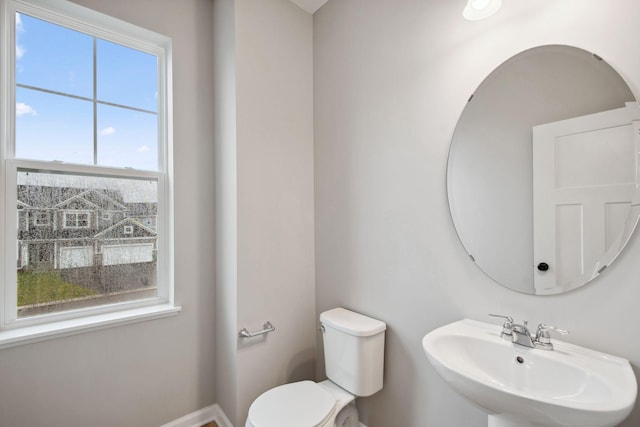 bathroom with a sink, baseboards, and toilet