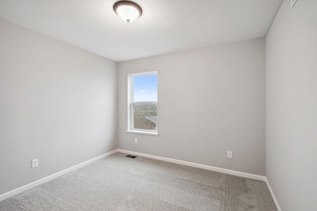 carpeted spare room with baseboards and visible vents