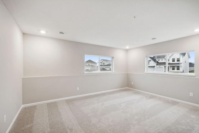 carpeted spare room featuring baseboards and recessed lighting