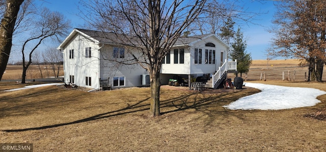 rear view of property featuring a yard and driveway