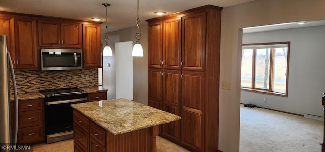 kitchen featuring light stone counters, decorative backsplash, a kitchen island, and appliances with stainless steel finishes