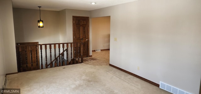 carpeted empty room with visible vents and baseboards