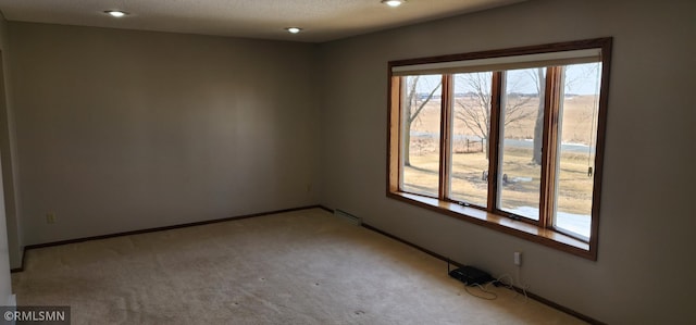 spare room featuring recessed lighting, baseboards, light carpet, and a textured ceiling