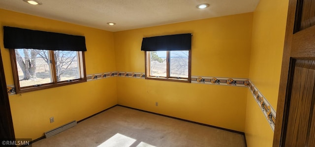 carpeted spare room with visible vents, plenty of natural light, and baseboards