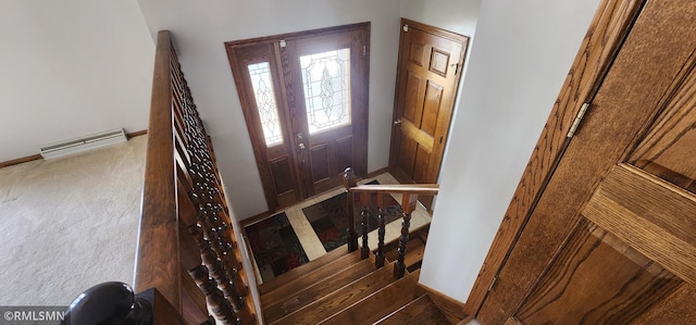 carpeted foyer featuring baseboard heating and baseboards