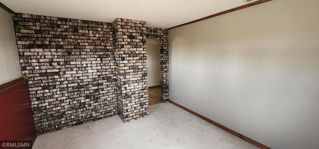 carpeted empty room featuring crown molding and baseboards