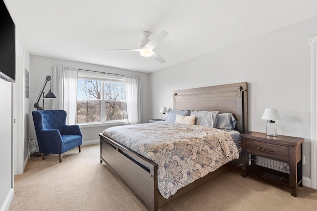 bedroom featuring ceiling fan, light carpet, and baseboards