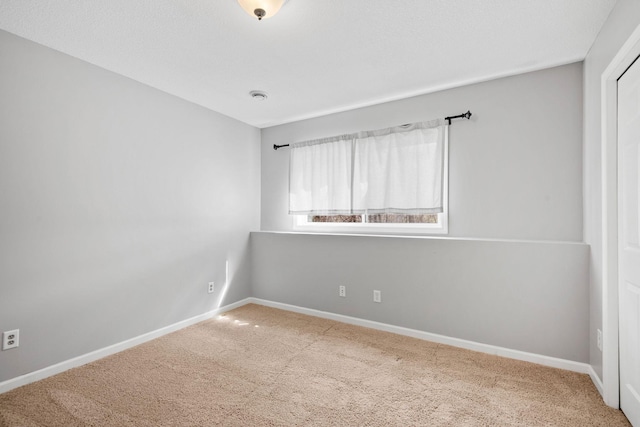 carpeted spare room with baseboards