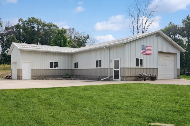 view of front of house featuring concrete driveway, a front lawn, and metal roof