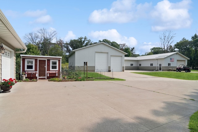 exterior space featuring a detached garage, a yard, and an outdoor structure