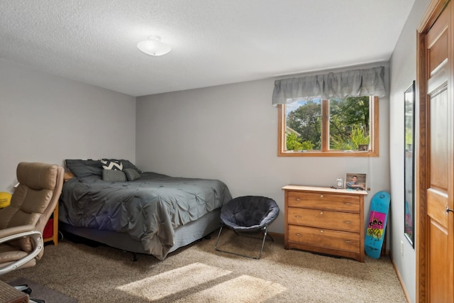 bedroom with light colored carpet and a textured ceiling