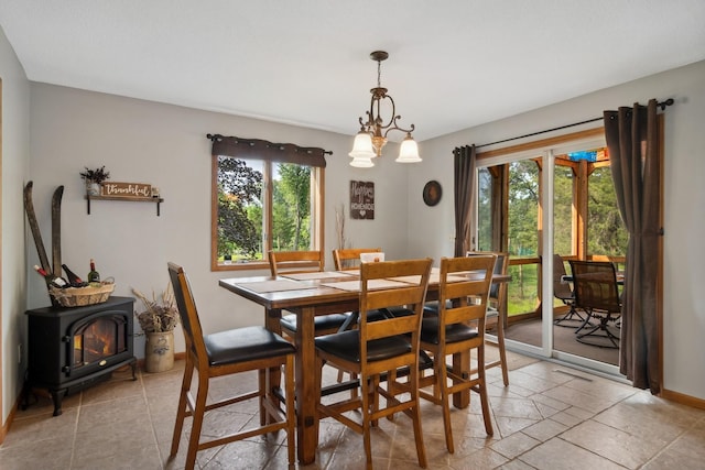 dining space with plenty of natural light, baseboards, and a wood stove