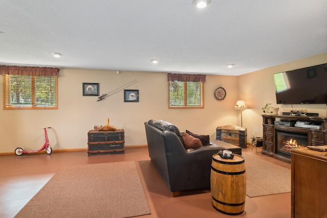living area featuring healthy amount of natural light and a glass covered fireplace