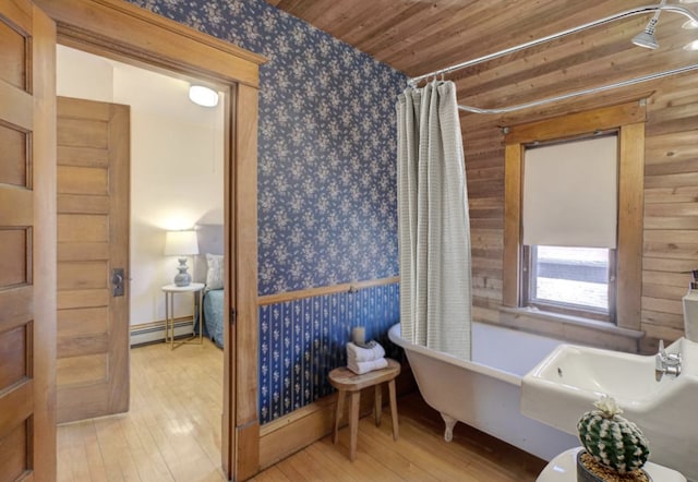 bathroom with a freestanding tub, a baseboard radiator, hardwood / wood-style floors, and wooden ceiling